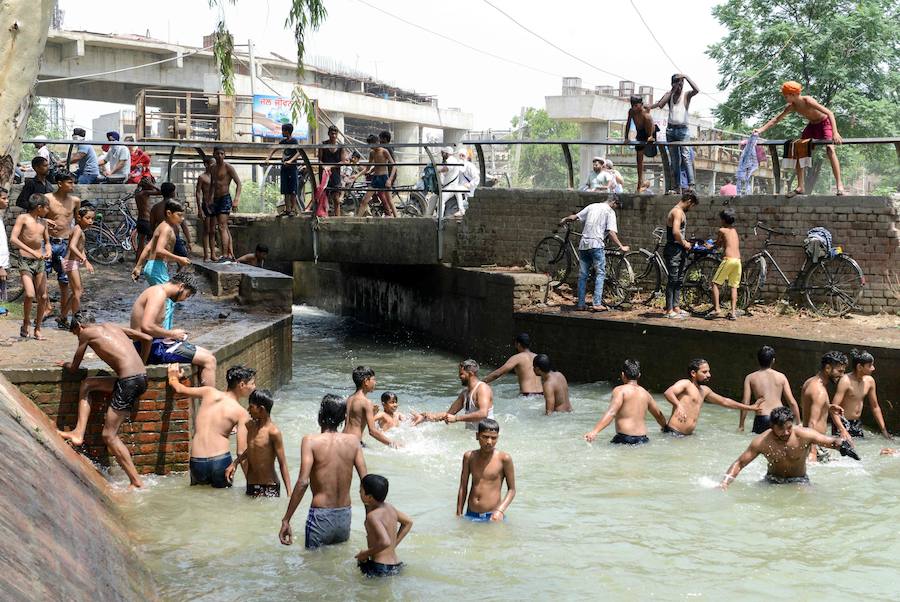 Un grupo de jóvenes se bañan en un canal de la India.