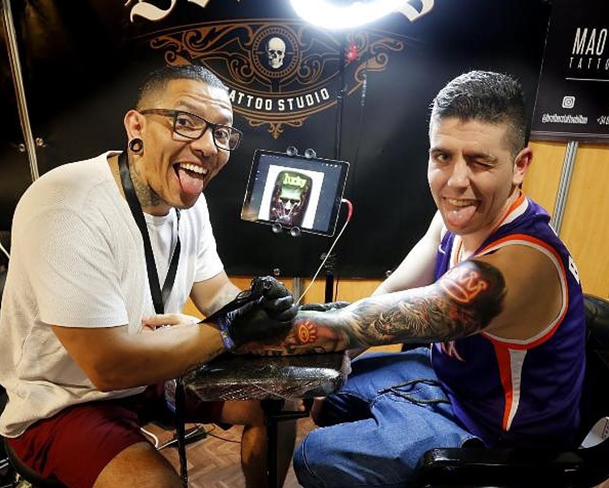 El colombiano llegado desde Bilbao Mao Calderón ultima un tatuaje «sobre el juego de la vida» en la piel de su paisano Cristian. 