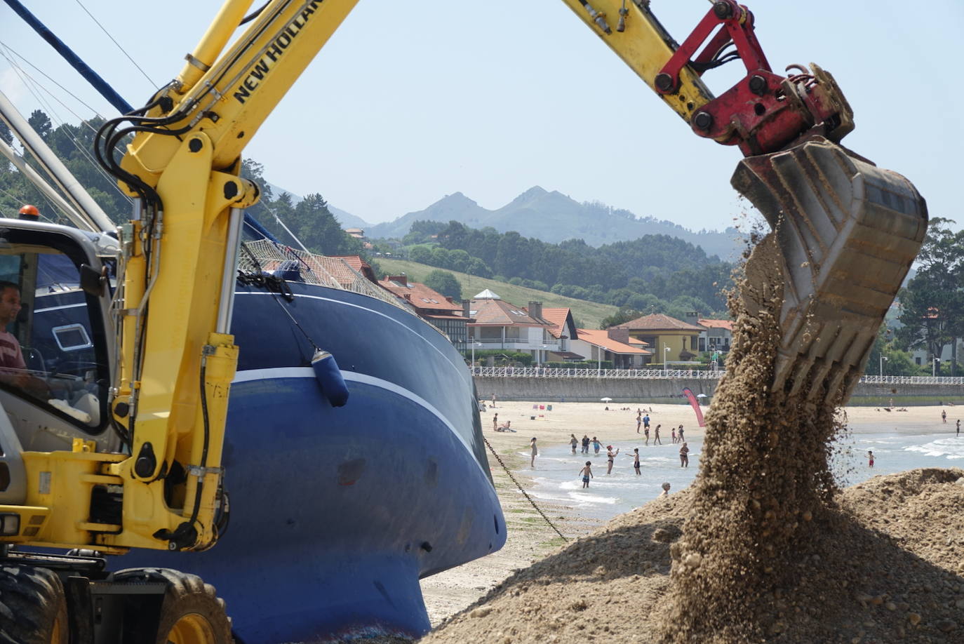 Una excavadora abre un canal en la playa de Santa Marina para intentar facilitar el posterior arrastre en pleamar del barco varado