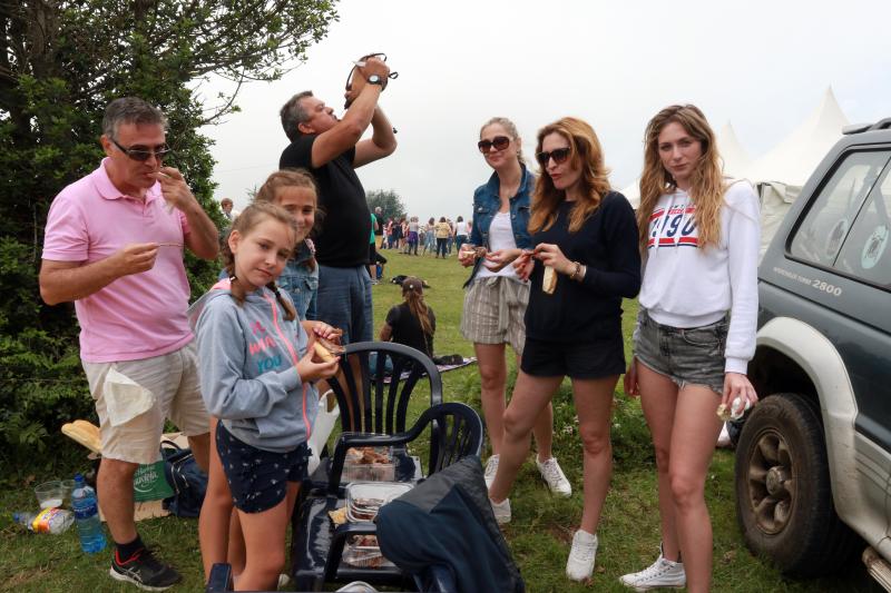 Centenares de personas han disfrutado en el prau Llagüezos del tradicional cordero a la estaca, plato principal de la fiesta de hermanamiento que se organiza entre los concejos de Quirós y Lena. A pesar de que la niebla ha cubierto buena parte de la celebración, el buen ambiente no se ha visto afectado.