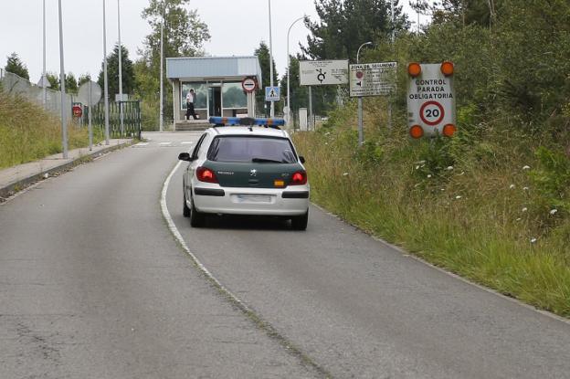 Un coche de la Guardia Civil, ayer, a punto de acceder a la prisión de Asturias. 