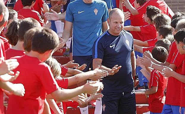 José Alberto choca las manos a los niños del campus que recibieron con un pasillo a la primera plantilla del Sporting. 