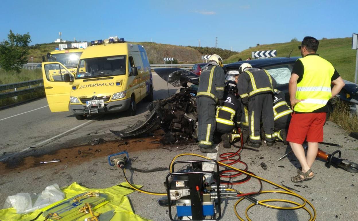 Los bomberos trabajan en uno de los coches siniestrados. 