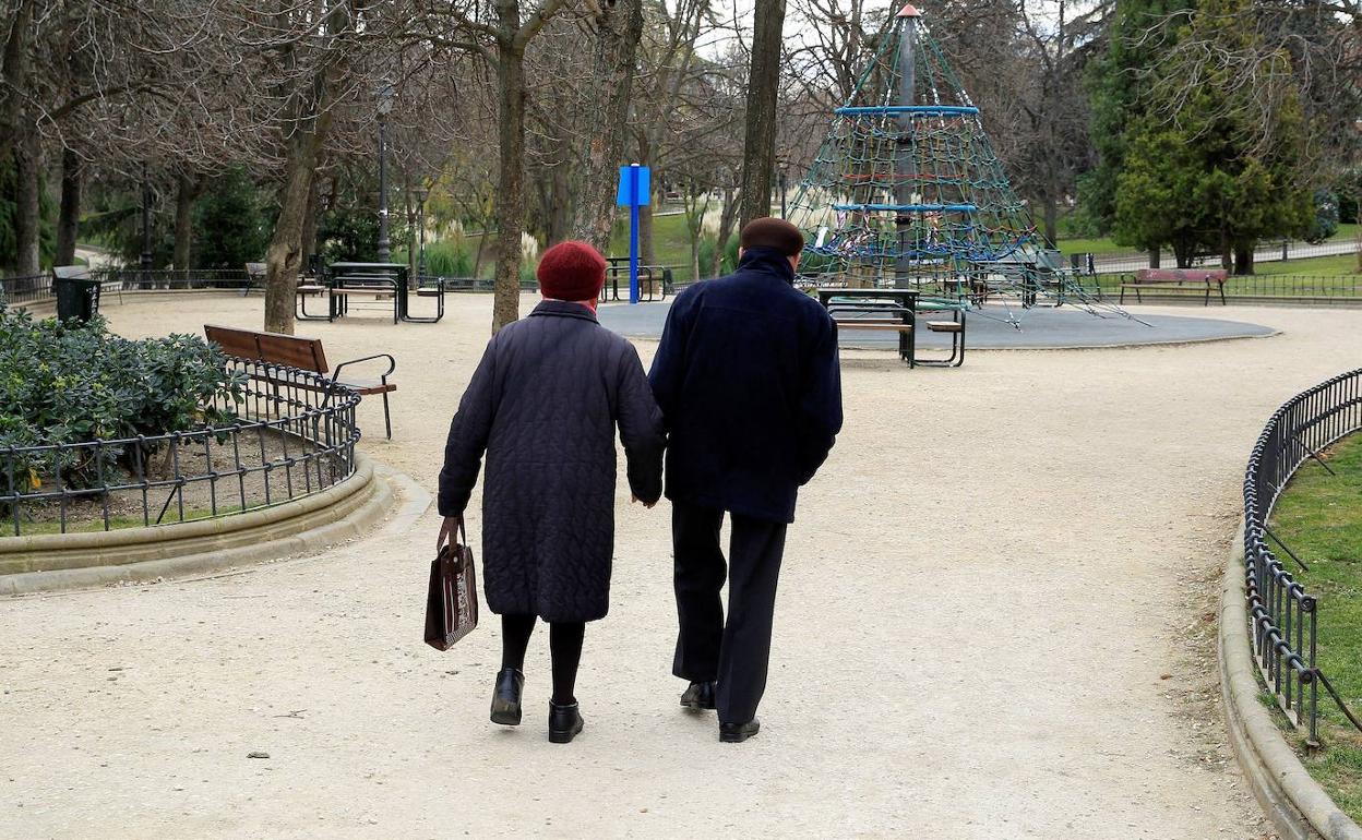 Una pareja camina por un parque.