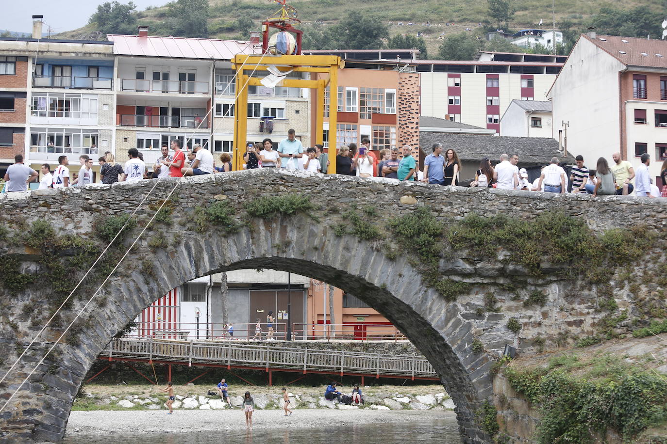 Miles de personas se reparten en los alrededores del Puente Romano y por las calles de la localidad para disfrutar de la tradicional Descarga que cada año hace vibrar a cangueses y visitantes.