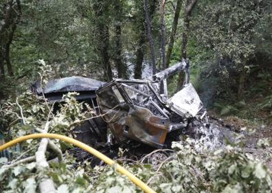 Imagen secundaria 1 - Incendio declarado en el lugar del accidente. Abajo, el camión accidentado y los bomberos evacuando el cadáver.