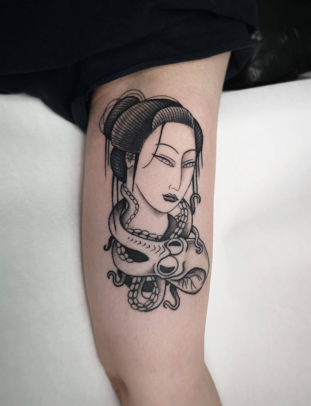 Tatuaje de la madrileña Iria Alcojor. Su obra se inspira en la naturaleza, el punk, el cómic, la cultura underground... Y camina entre el macarreo y la oscuridad, con un guiño divertido y a veces un tanto naif. Trabaja solo con tinta negra y sus tatuajes son siempre muy claros.