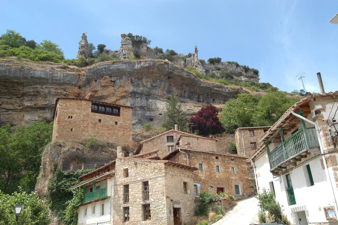 Orbaneja del Castillo (Burgos): Si por algo destaca este pueblo burgalés es por el la magia de su paisaje modelado por el agua. Del municipio, declarado Conjunto Histórico, destacan sus estrechas calles medievales, las pozas y las casas de cuento, todo con Cañón del río Ebro de fondo. No obstante, si existe una imagen idílica de este paraje es la que genera la Cueva del Agua y es, además, la primera con la que te vas a encontrar al visitar el pueblo: casas atravesadas por las aguas del arroyo, que cae en forma de escalera de unos 25 metros de altura, formando una casacada.