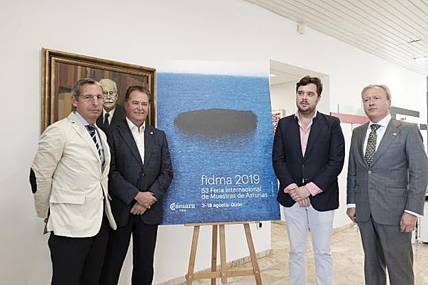 Pedro López Ferrer, Félix Baragaño, Hugo Fontela y Álvaro Alonso, en las oficinas de la Cámara junto al cartel de la Fidma. 