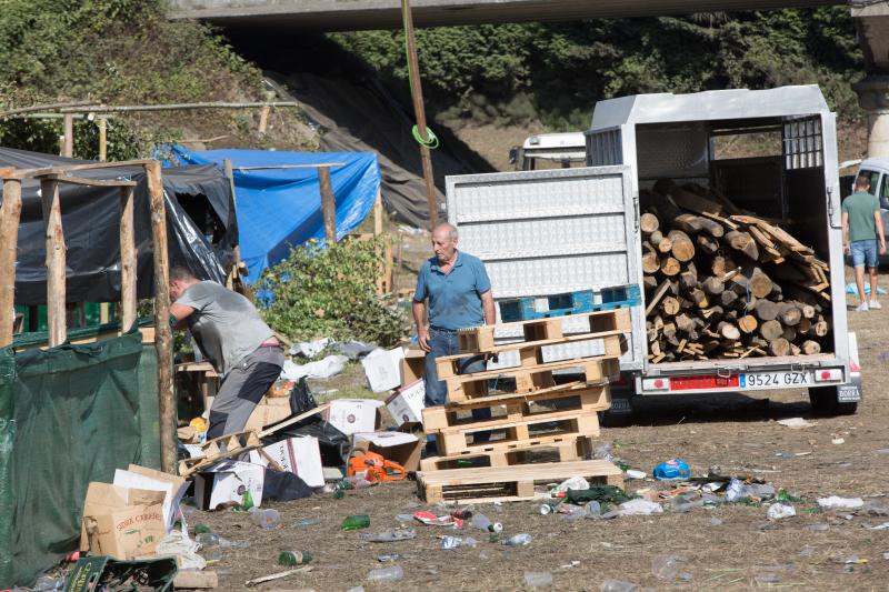 La multitudinaria fiesta del Xiringüelu ha dejado toneladas de basura en el prau Salcéu. Botellas, vasos, y restos de las coloridas casetas que son seña de identidad de la celebración han quedado esparcidos por el campo a la espera de que se retiren, unas labores que ya han comenzado.