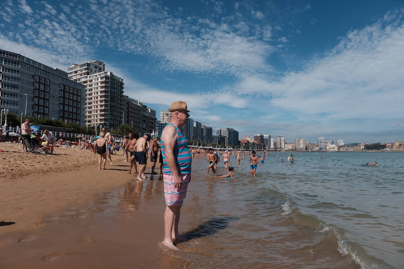 Un baño en la playa para combatir el calor en Gijón