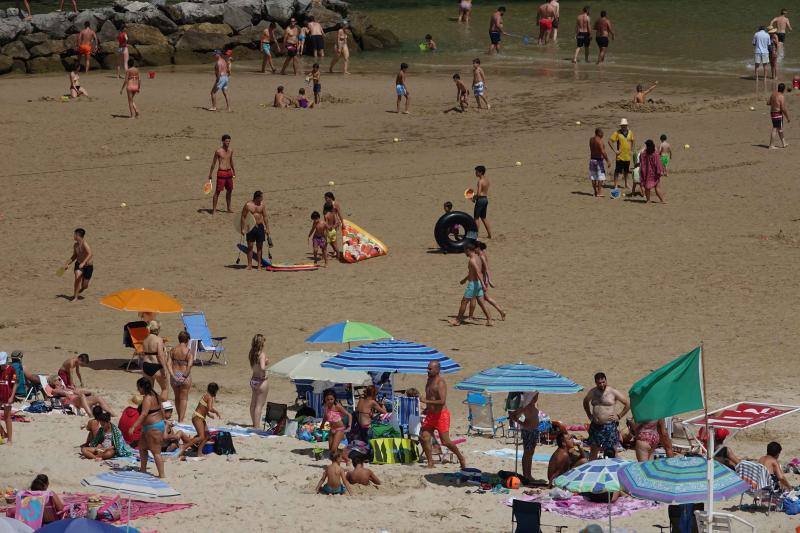 Un baño en la playa para combatir el calor en Gijón