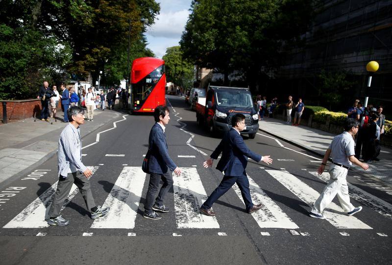 No hay duda. La foto de The Beatles cruzando por el paso de peatones de Abbey Road es una de las fotos más famosas de la historia de la música. Esa imagen cumple hoy 50 años y, para celebrarlo, centenares de fans se han congregado en la icónica calle. Incluso un grupo de imitadores del grupo británico llegó a la calle del barrio londinense de St John's Wood en una réplica del psicodélico Rolls Royce de John Lennon. Toda una gran fiesta para para conmemorar la iamgen que inmortalizó el escocés Iain Macmillan a las 11 horas y 35 minutos del 8 de agosto de 1969. En una sesión fotográfica de diez minutos hizo solo seis fotos y la que se convirtió en la imagen del álbum 'Abbey Road' fue la quinta, en la que los cuatro músicos caminan al unísono.