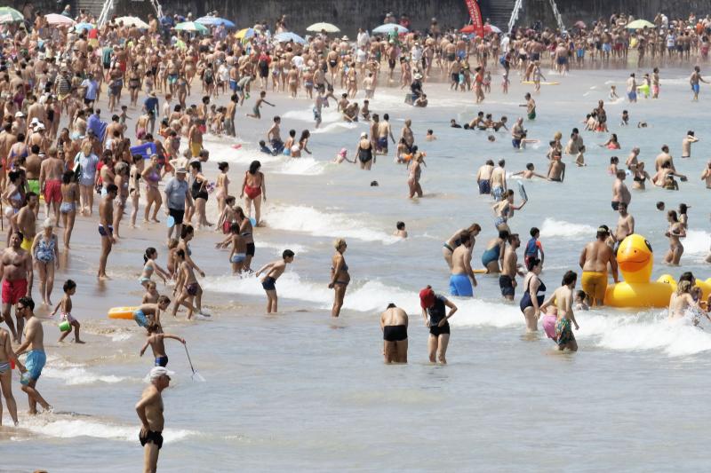 Difícil encontrar sitio en la arena para estirar la toalla. El sol y las altas temperaturas de este sábado han animado a miles de personas a disfrutar de las playas de la región, como muestras las imágenes de San Lorenzo, Salinas y Candás.