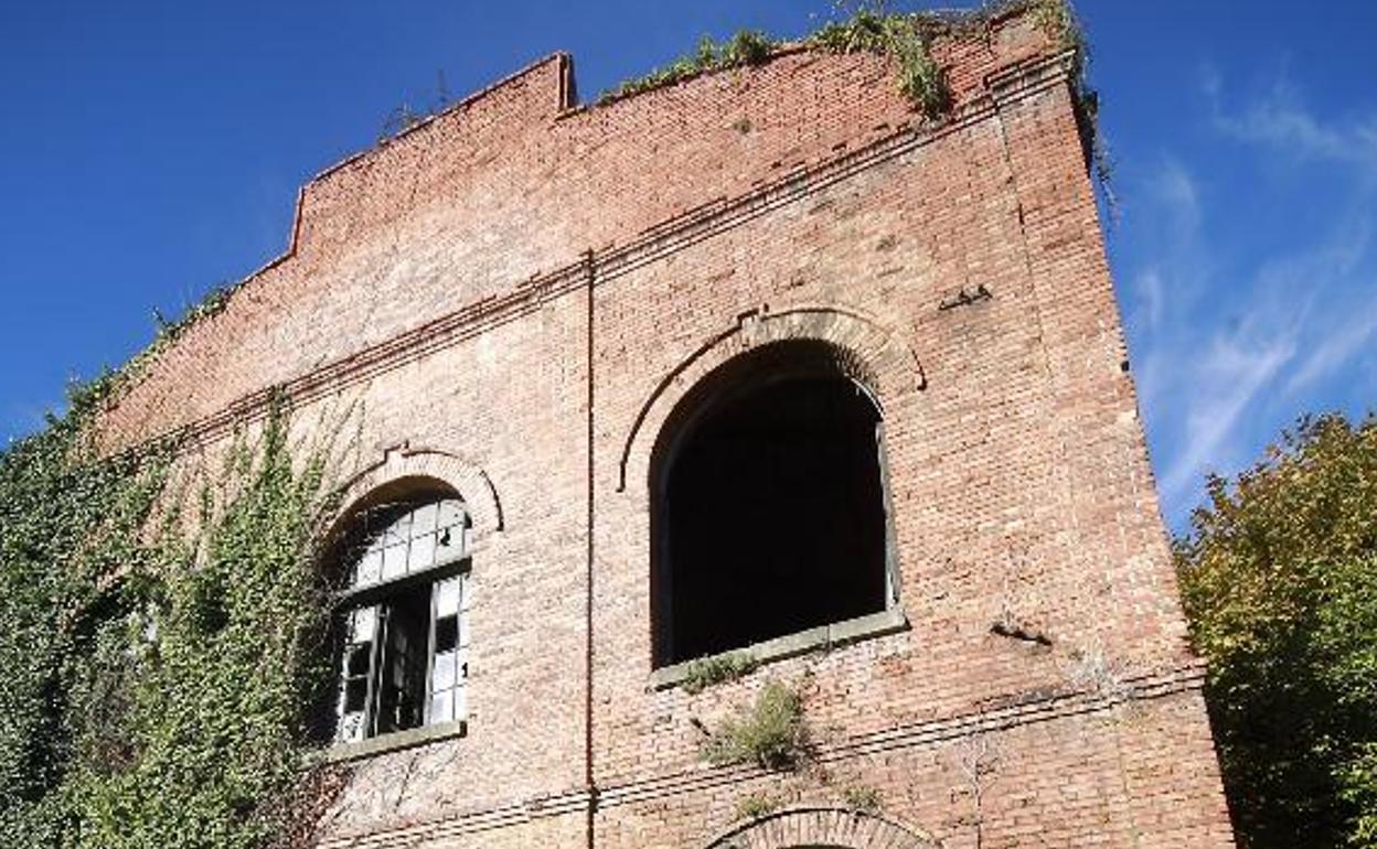 Una mujer frente a una nave de la antigua fábrica de La Vega.