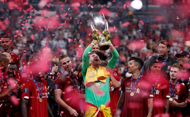 Adrián San Miguel levanta la Supercopa de Europa con el Liverpool con su toalla al cuello y la bandera de España en la cintura en el Besiktas Park de Estambul
