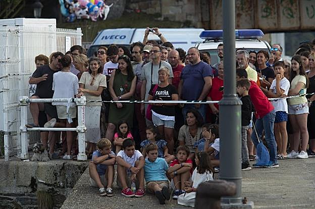 Arriba, izado de la ballena en el puerto de Navia. Abajo, su traslado por mar y curiosos. 