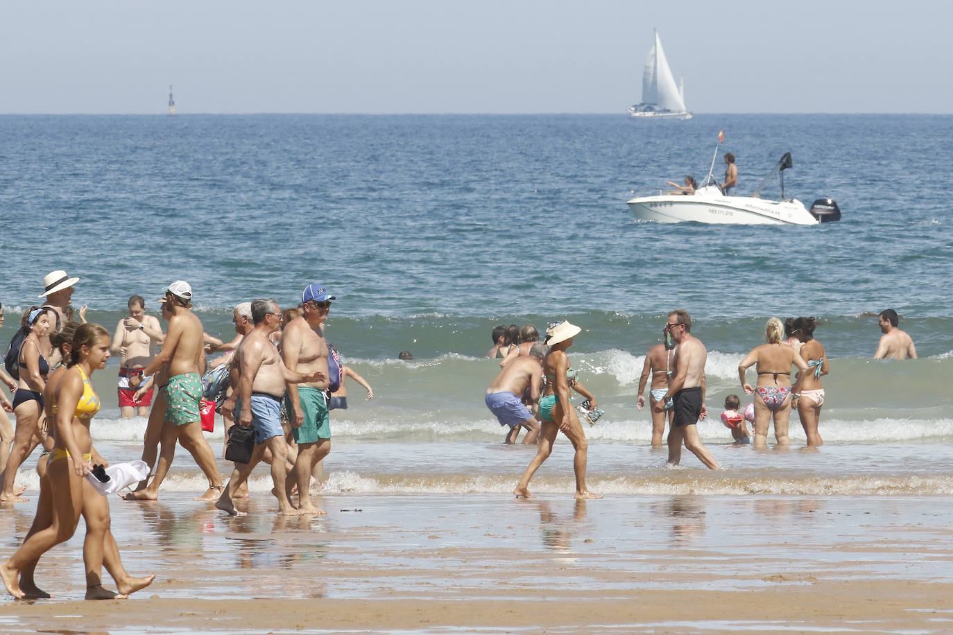El arenal gijonés se llena en una jornada en la que se superan los 25 grados de temperatura.