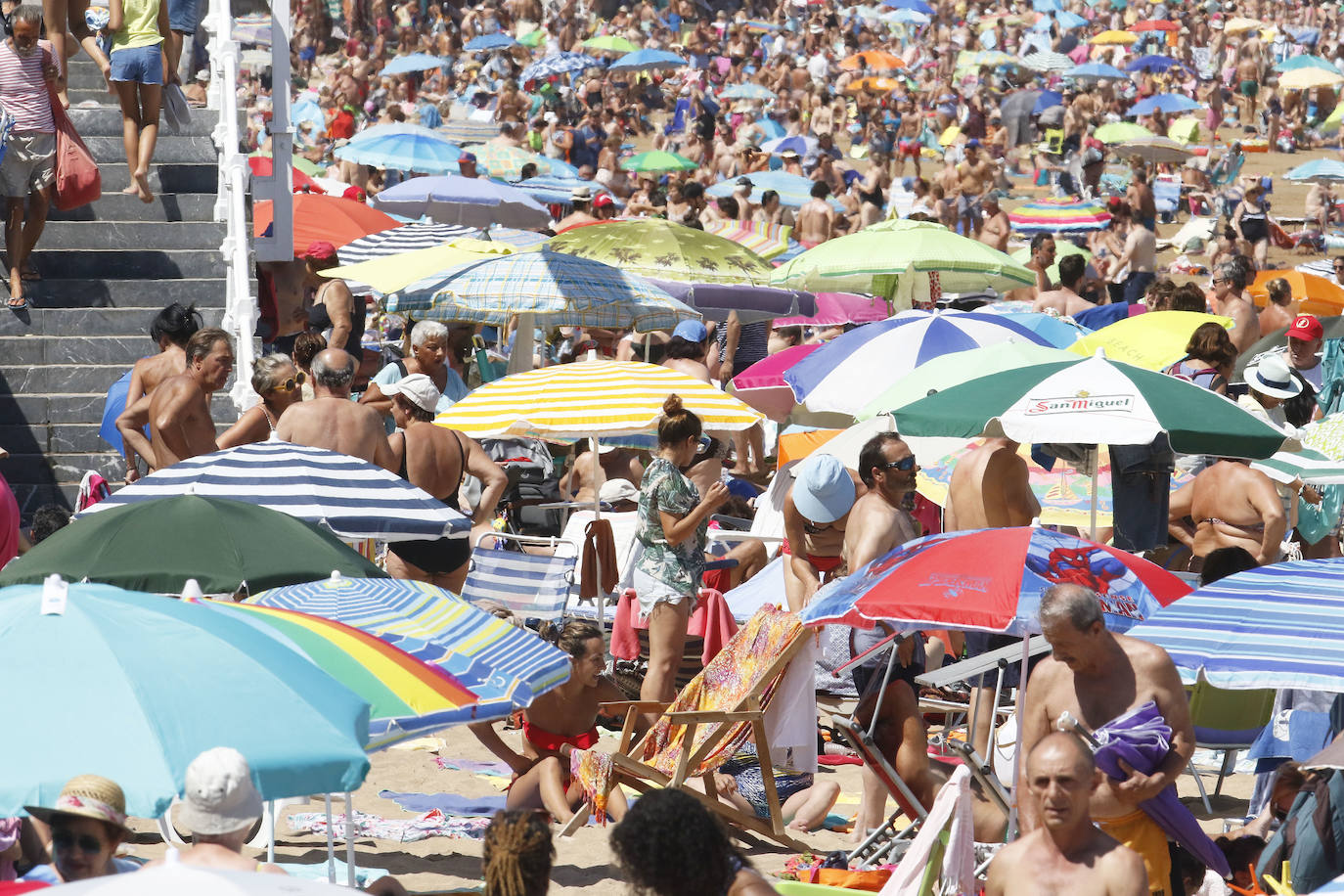 El arenal gijonés se llena en una jornada en la que se superan los 25 grados de temperatura.