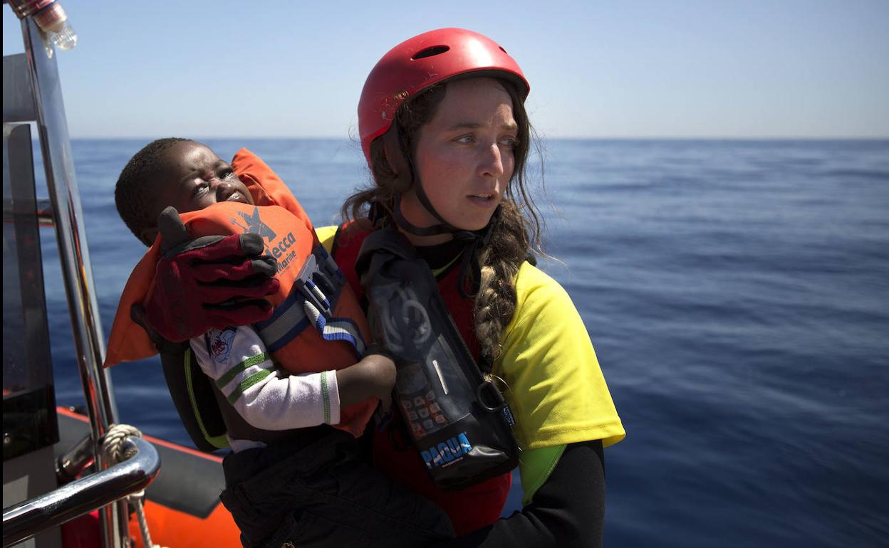 Rescate. Anabel Montes sujeta en brazos a un pequeño rescatado, en junio de 2017, en la costa de Libia. 