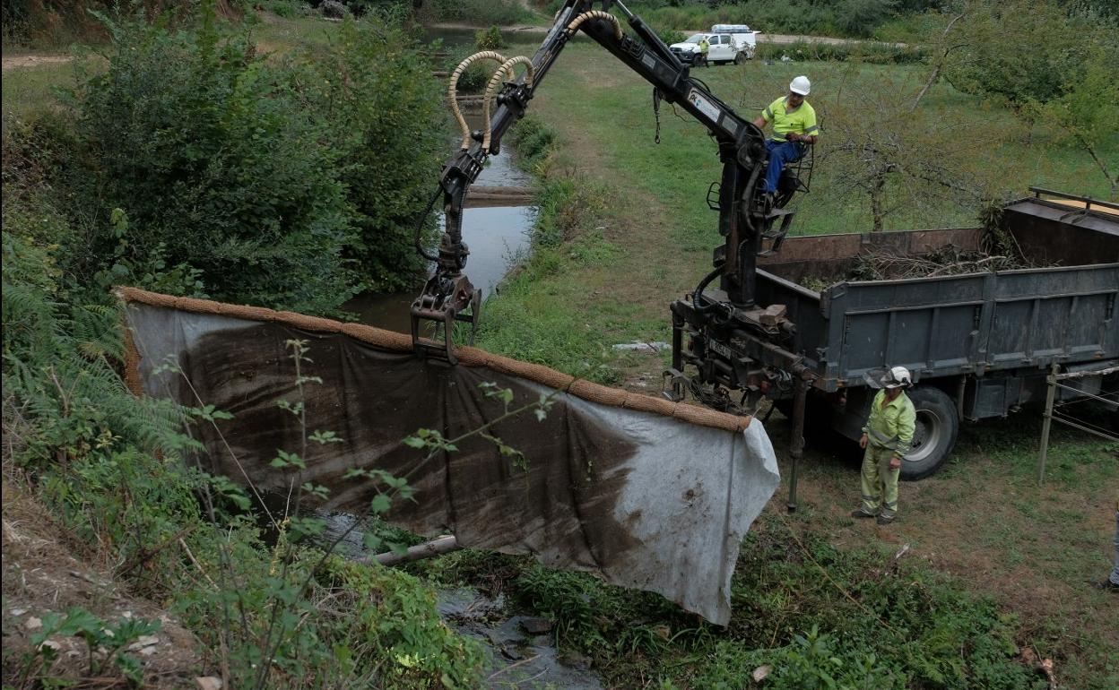 Una de las seis barreras anticontaminación que los operarios de Tragsa instalaron a lo largo de la mañana de este martes en el arroyo Ouria. / CAROLINA SANTOS