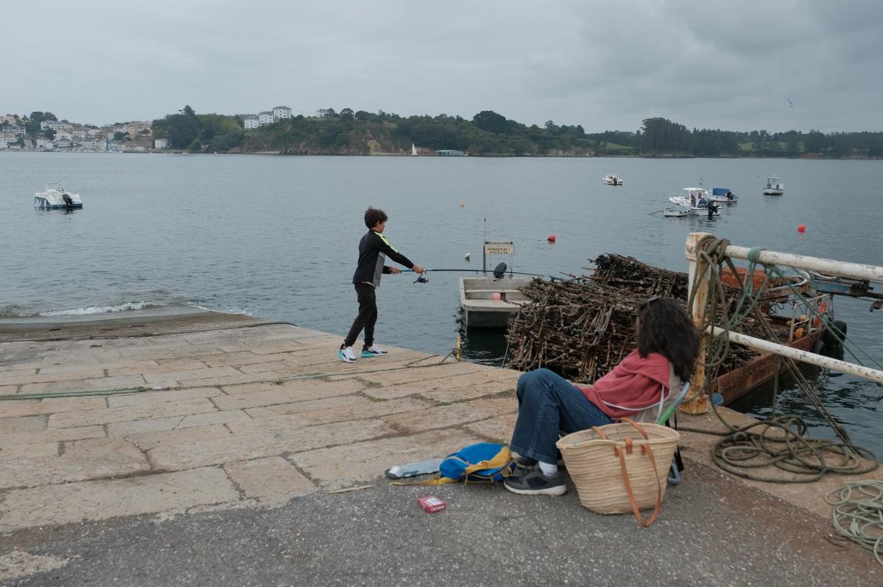 Un niño lanza la caña en la ría del Eo. 