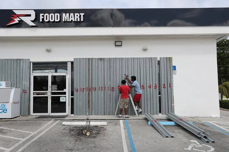 Trabajadores de un supermercado instalan barreras protectoras en Riviera Beach, Florida.