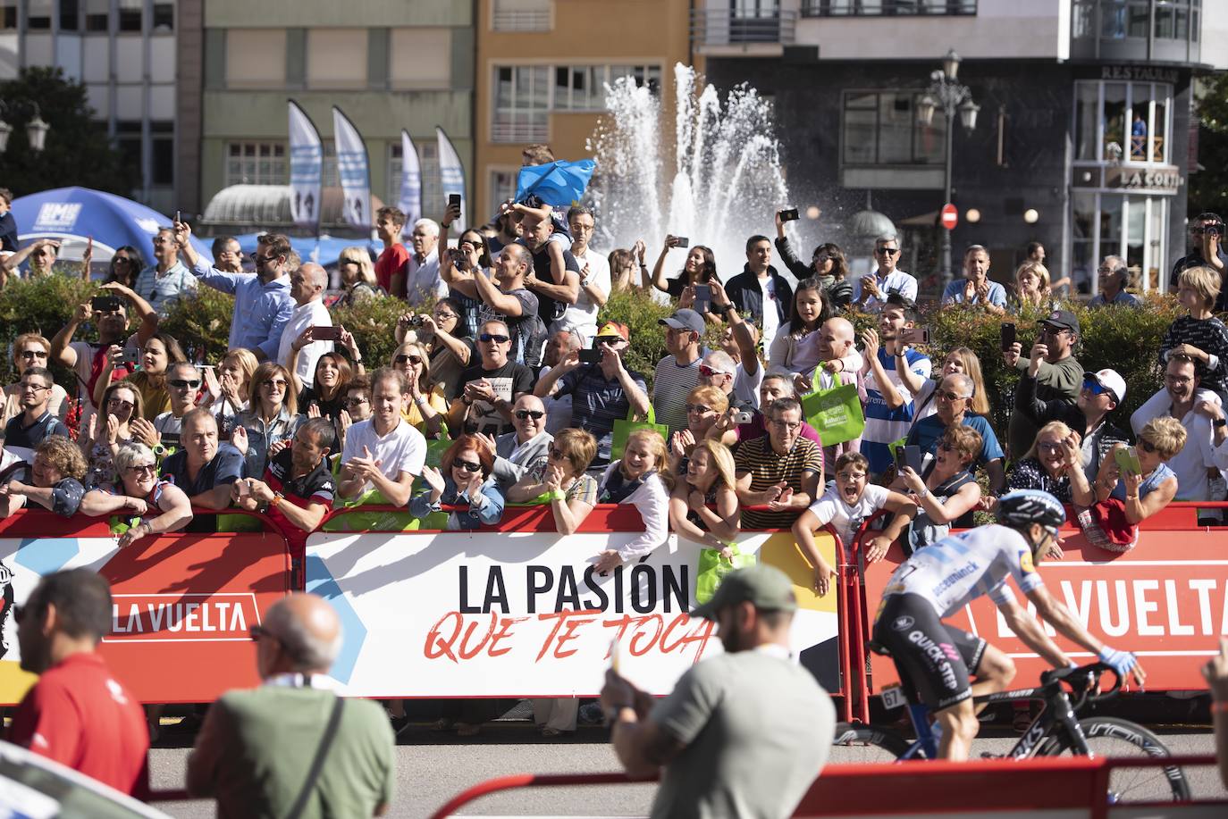 Numerosos aficionados se agolparon en la calle Uría de la capital para ver a los corredores en la etapa 14 entre San Vicente de la Barquera y Oviedo. 