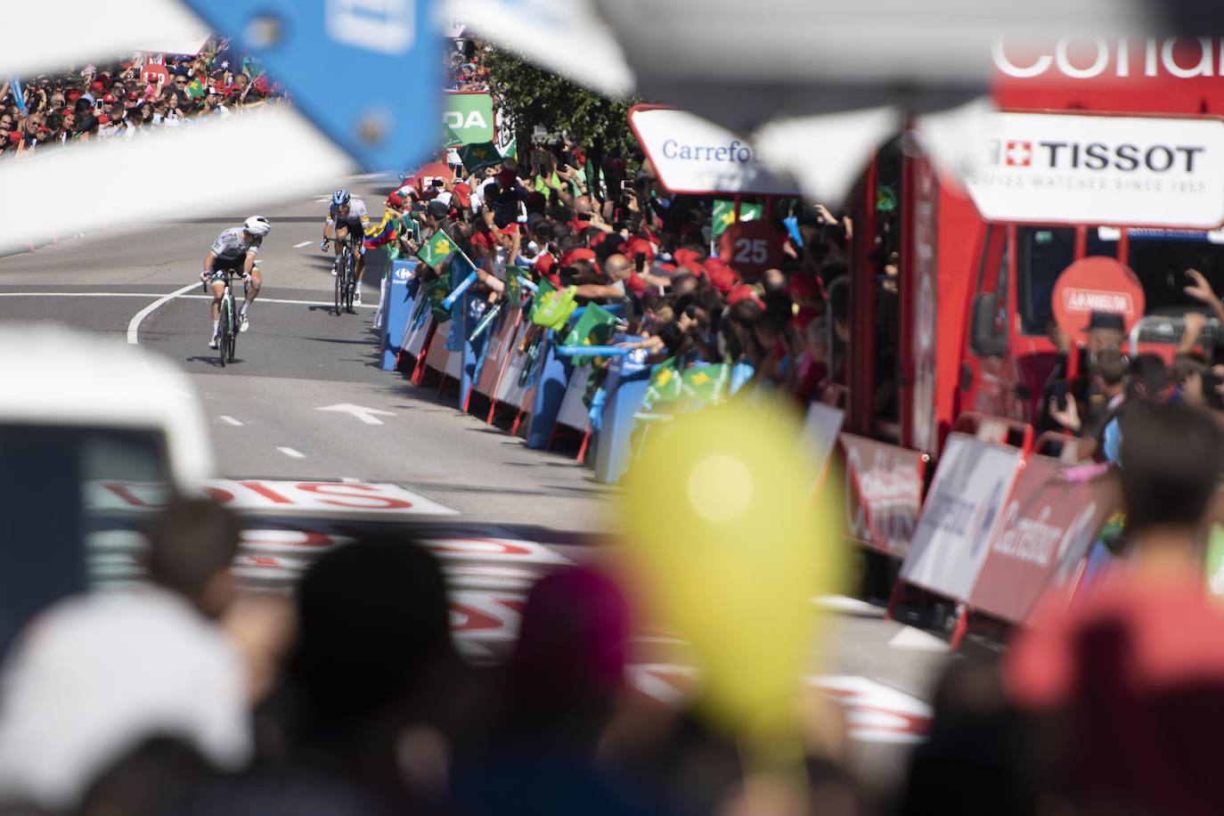 Numerosos aficionados se agolparon en la calle Uría de la capital para ver a los corredores en la etapa 14 entre San Vicente de la Barquera y Oviedo. 