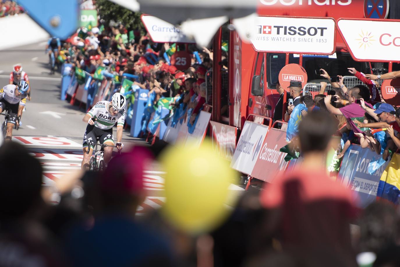 Numerosos aficionados se agolparon en la calle Uría de la capital para ver a los corredores en la etapa 14 entre San Vicente de la Barquera y Oviedo. 