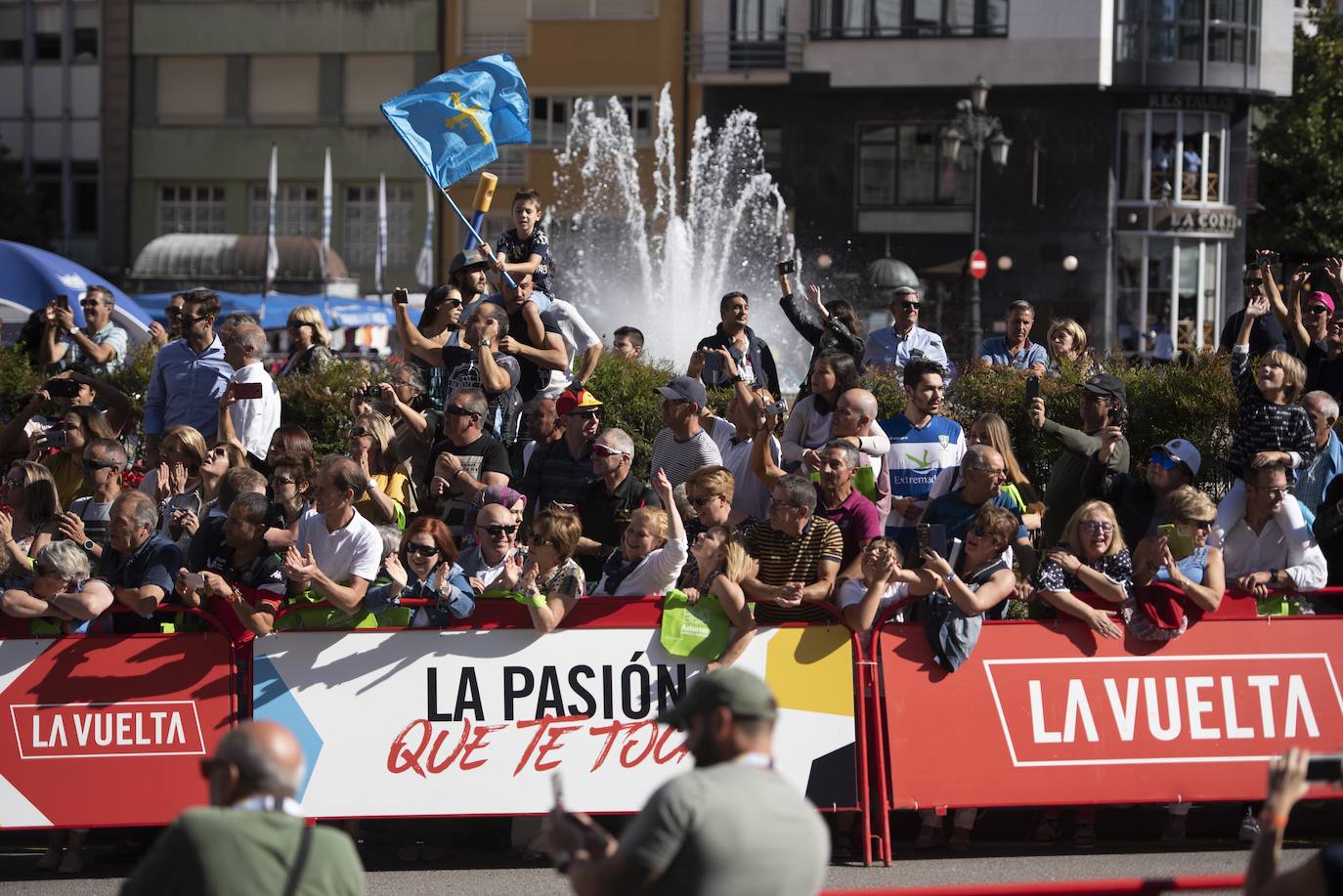 Numerosos aficionados se agolparon en la calle Uría de la capital para ver a los corredores en la etapa 14 entre San Vicente de la Barquera y Oviedo. 