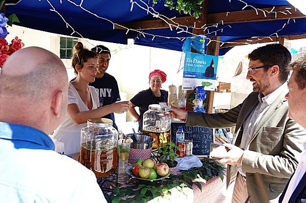 El consejero Enrique Fernández compra un 'asturjito' en un puesto en Arenas. 
