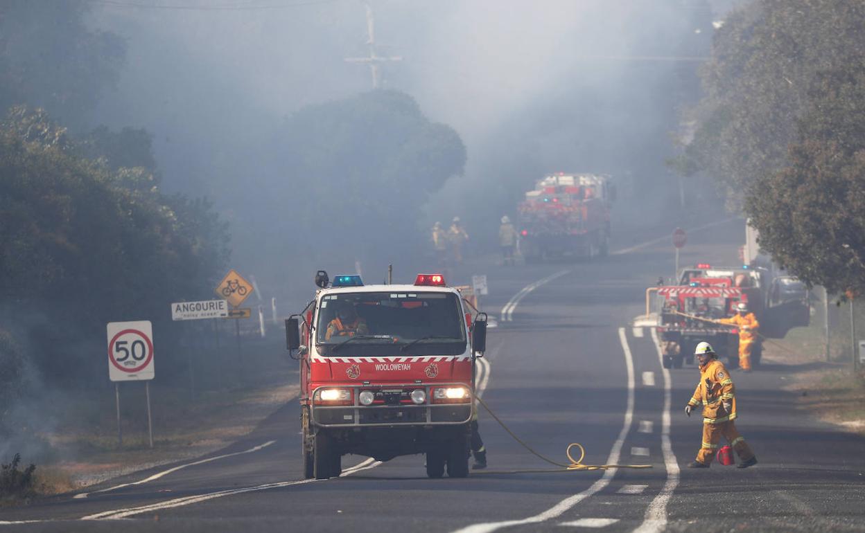 Los equipos de extinción cortan una carretera afectada por los fuegos en Australia.