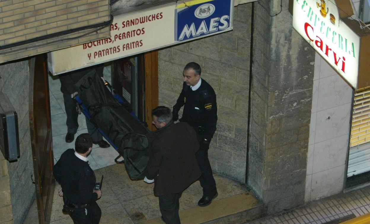 Policías y personal de la funeraria sacan el cadáver del local de la calle Ezcurdia. 