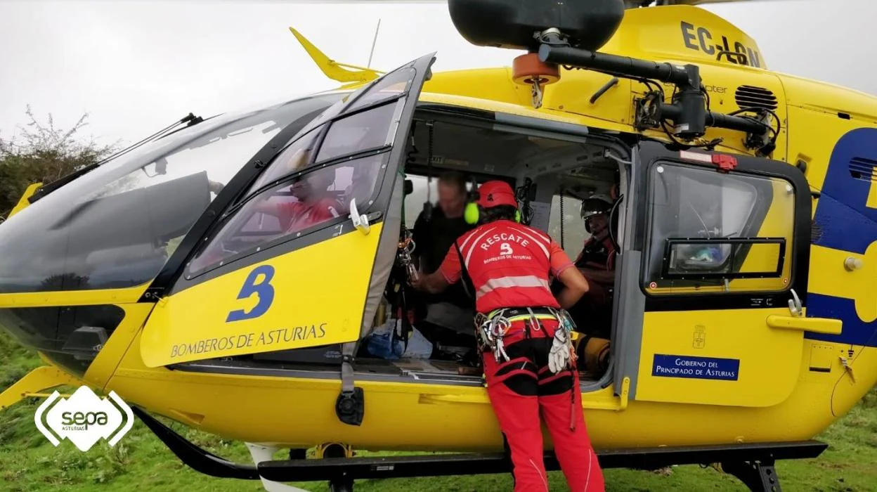 Los rescatadores conversan con el montañero inglés tras subirlo a la aeronave. 