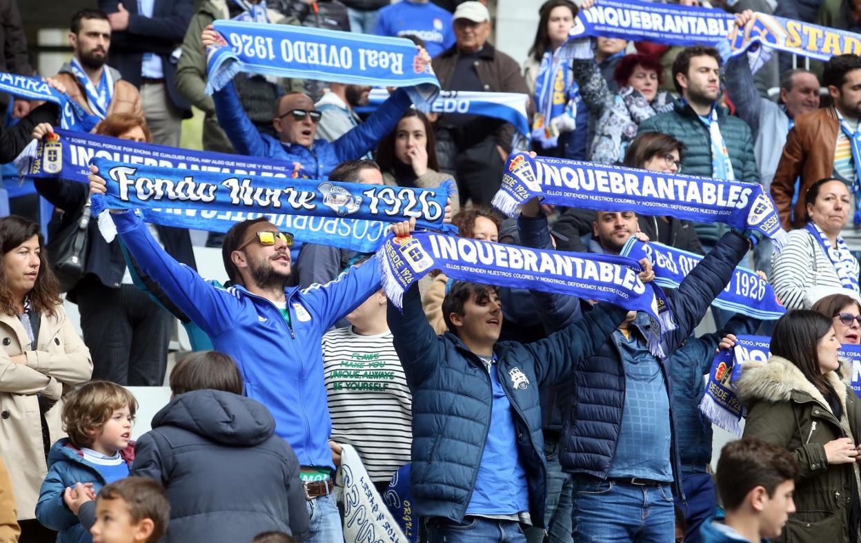 Unos aficionados exhibiendo las bufandas del Rel Oviedo durante un partido. 