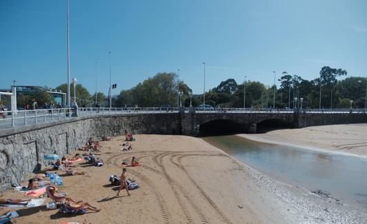 Varias personas disfrutan del sol este sábado junto al río Piles.
