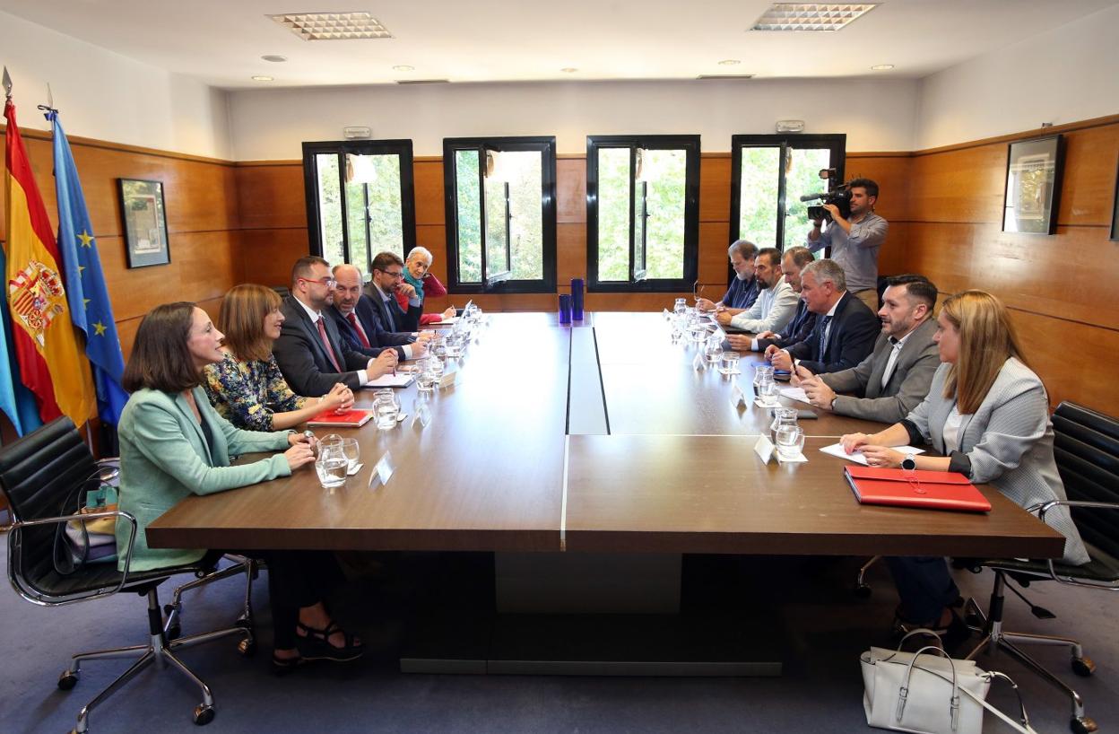 El presidente del Principado junto a sus consejeros, en el lazo izquierdo de la mesa, y los representantes de los agentes sociales, en el derecho, antes de iniciar la reunión. 