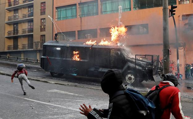 Los manifestantes atacan con bombas incendiarias una tanqueta de la Policía.