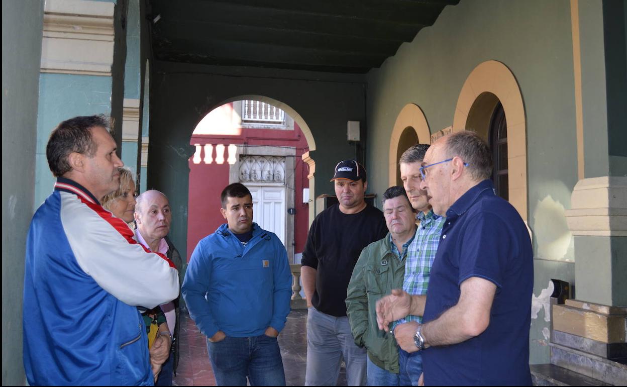 Comerciantes de Tineo conversan con el alcalde, José Ramón Feito (segundo por la derecha).