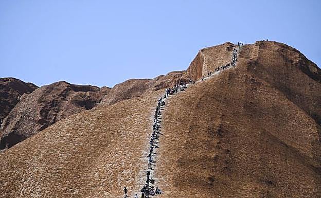 Cientos de turistas suben por última vez al monolito sagrado Uluru en Australia