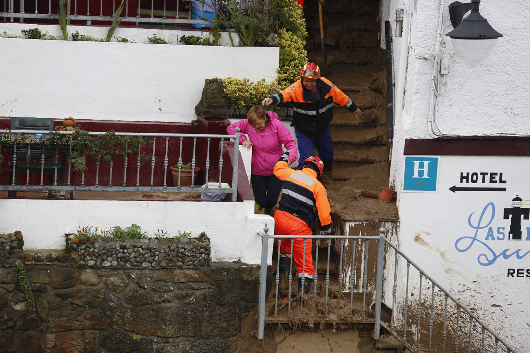 Los operarios han tenido que dedicarse a fondo tras el argayu de Tazones que ha obligado a desalojar dos establecimientos hosteleros y una vivienda y amenaza a otros edificios. 