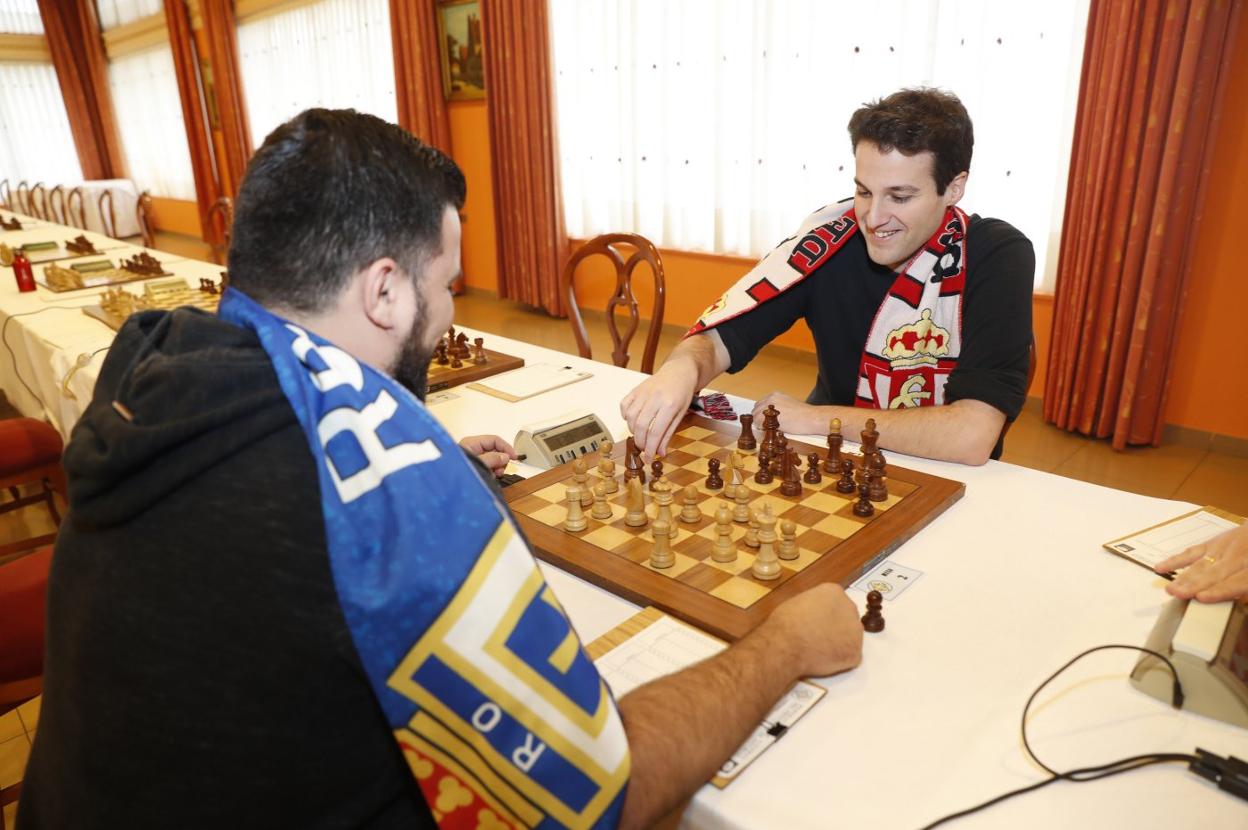 Ignacio Bajo, Enrique Álvarez, Alberto Cuevas y Belarmino García con la bandera asturiana. Abajo, Cuevas y Álvarez ante el tablero. 