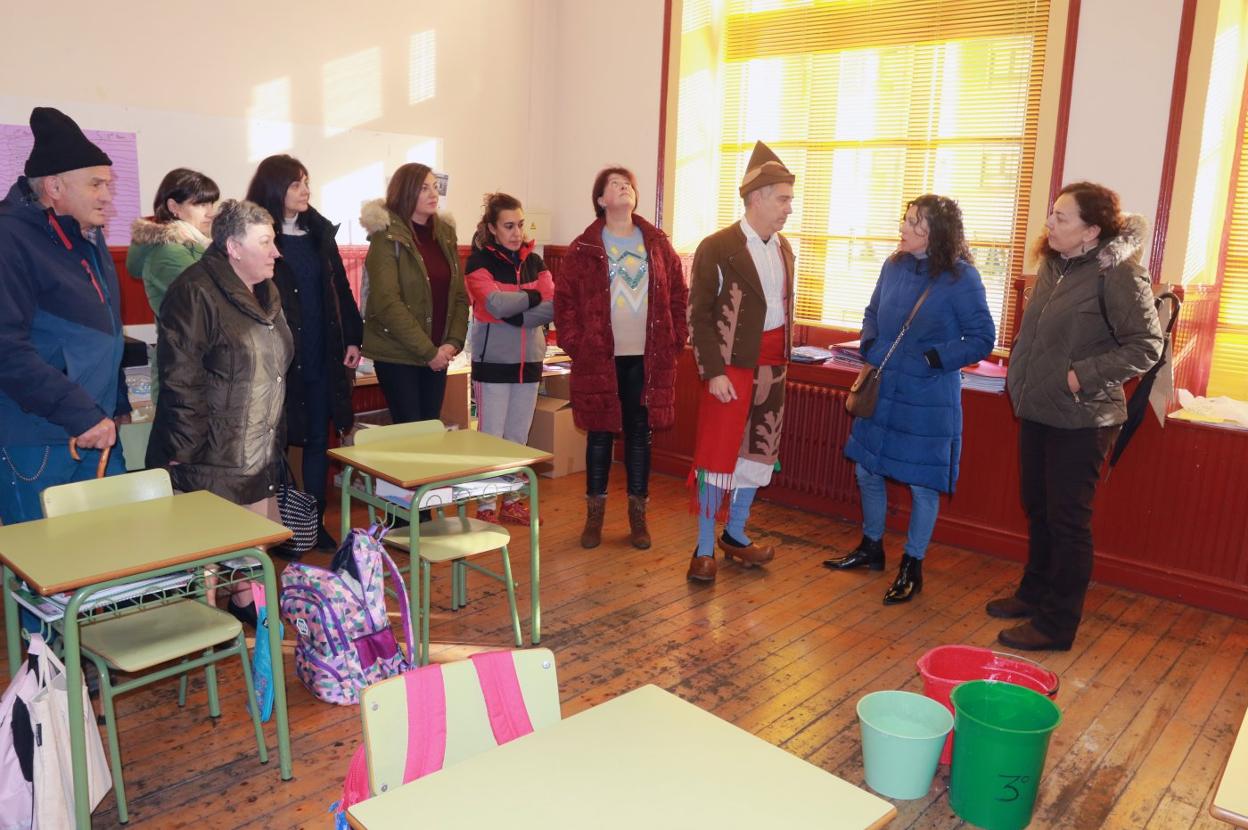 El director del colegio explica a las representantes de Podemos y a varios padres y madres de alumnos la situación del centro. 