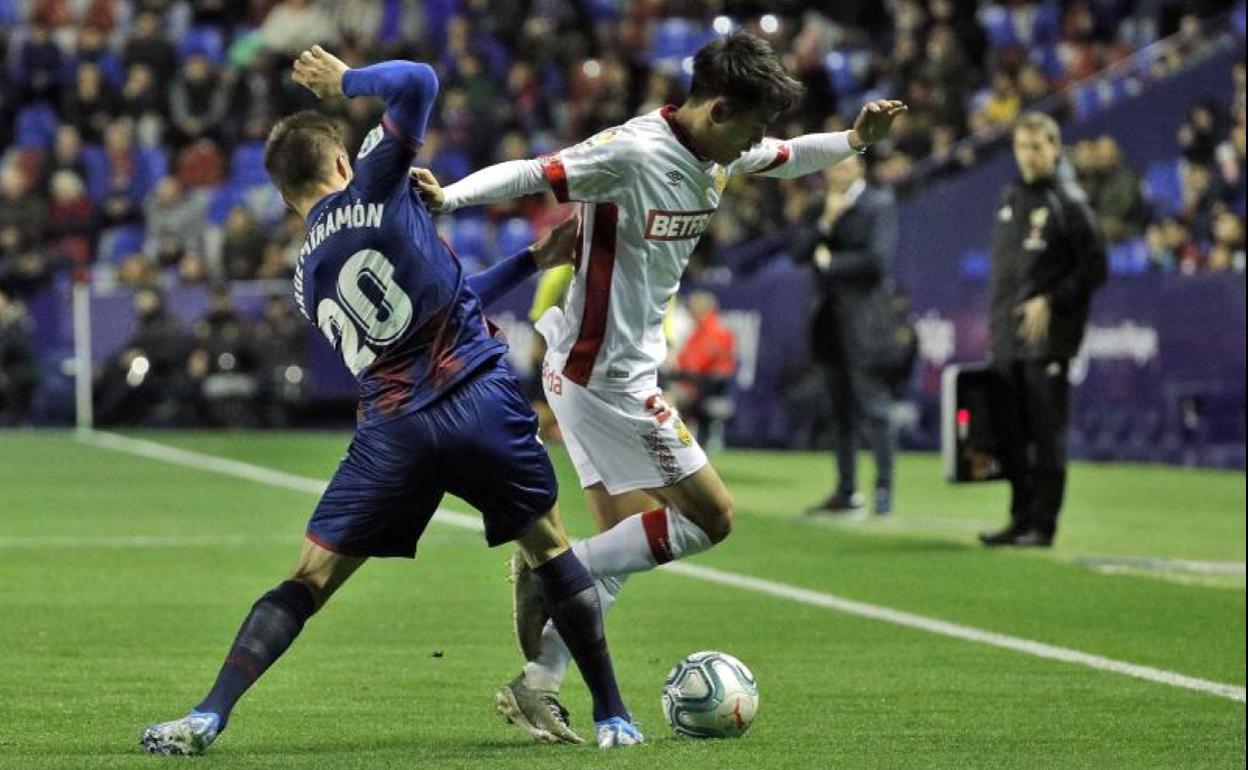 El centrocampista japonés del RCD Mallorca, Takefusa Kubo, intenta llevarse el balón ante el defensa del Levante, Jorge Miramón.