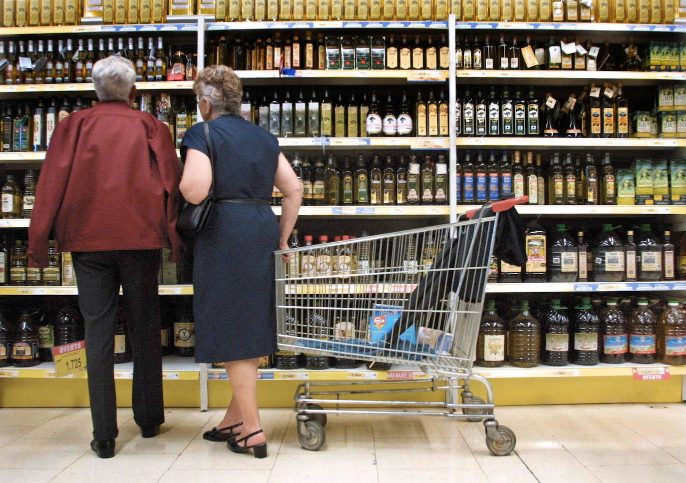 Dos clientes revisan los precios en un supermercado. 