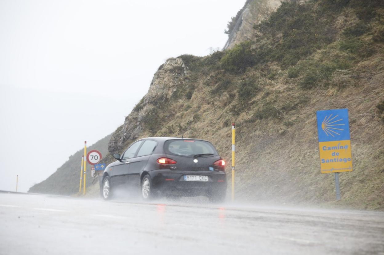 Un coche circula ayer por el alto del puerto de Pajares, el cual restringió el paso de vehículos pesados a mitad de tarde 