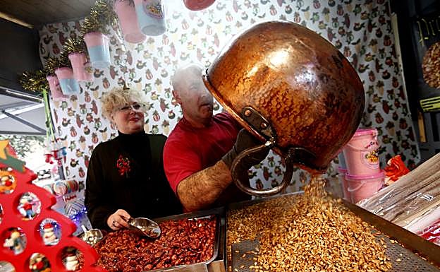 Rosa de Castro y Mauro Asenjo en su puesto de garrapiñadas del mercadillo navideño de Porlier.