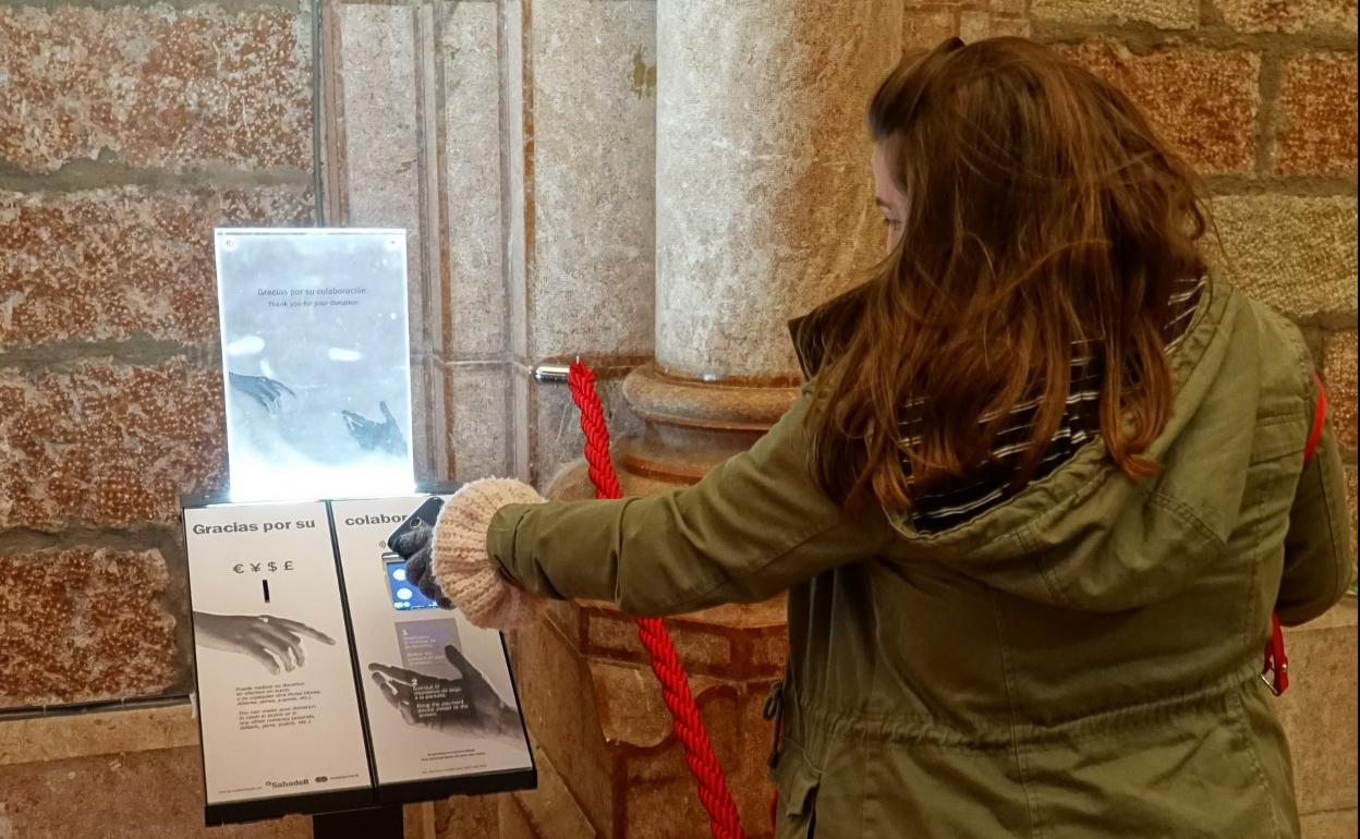Una turista utiliza el 'cepillo' digital para hacer una donación. 