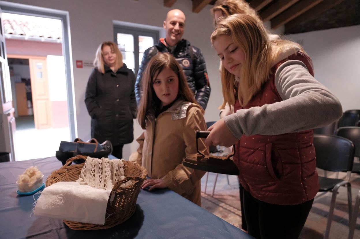 Irene y Laia descubren cómo era una antigua plancha. 